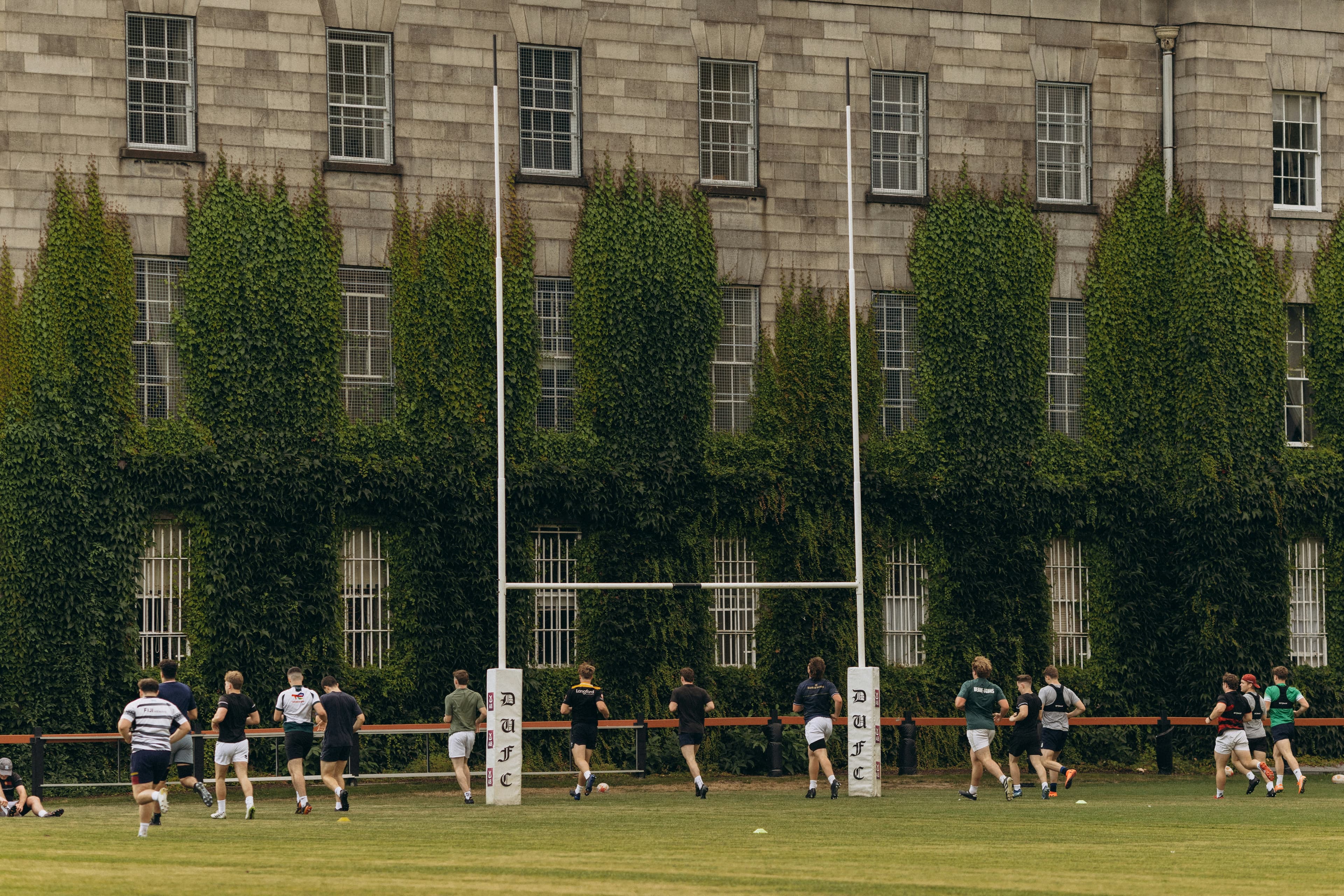 A school rugby team training in front of the main building